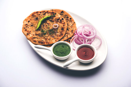 Onion Parotha / Pyaj parantha / kanda paratha served with tomato ketchup and green chutney. selective focus