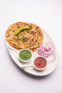 Onion Parotha / Pyaj parantha / kanda paratha served with tomato ketchup and green chutney. selective focus