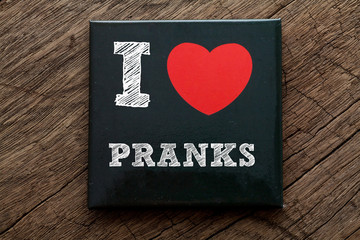 I Love My Pranks written on black note with wood background