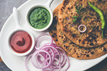 Onion Parotha / Pyaj parantha / kanda paratha served with tomato ketchup and green chutney. selective focus