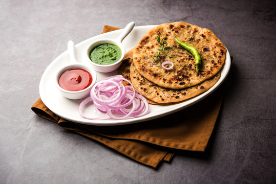 Onion Parotha / Pyaj parantha / kanda paratha served with tomato ketchup and green chutney. selective focus