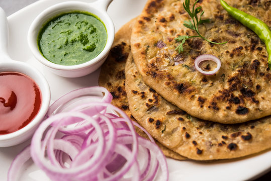 Onion Parotha / Pyaj parantha / kanda paratha served with tomato ketchup and green chutney. selective focus
