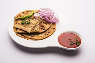 Onion Parotha / Pyaj parantha / kanda paratha served with tomato ketchup and green chutney. selective focus