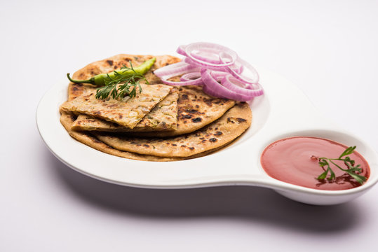 Onion Parotha / Pyaj parantha / kanda paratha served with tomato ketchup and green chutney. selective focus