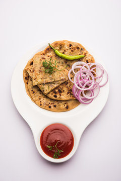 Onion Parotha / Pyaj parantha / kanda paratha served with tomato ketchup and green chutney. selective focus