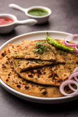 Onion Parotha / Pyaj parantha / kanda paratha served with tomato ketchup and green chutney. selective focus
