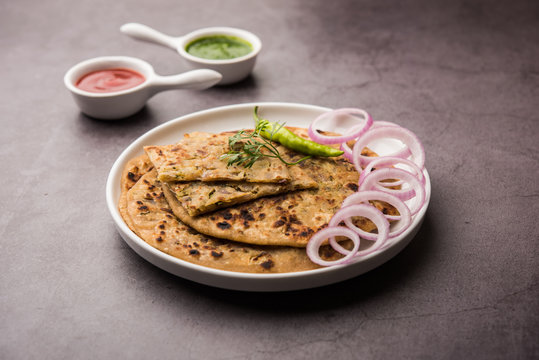 Onion Parotha / Pyaj parantha / kanda paratha served with tomato ketchup and green chutney. selective focus