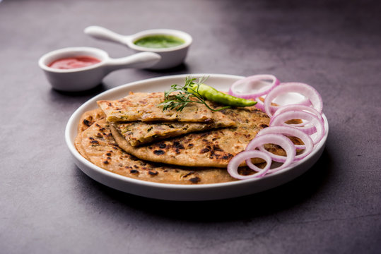 Onion Parotha / Pyaj parantha / kanda paratha served with tomato ketchup and green chutney. selective focus