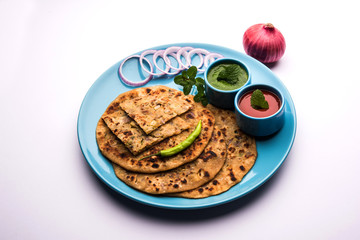 Onion Parotha / Pyaj parantha / kanda paratha served with tomato ketchup and green chutney. selective focus