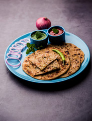 Onion Parotha / Pyaj parantha / kanda paratha served with tomato ketchup and green chutney. selective focus