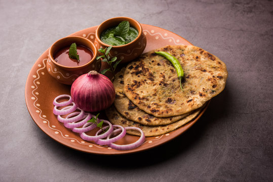 Onion Parotha / Pyaj parantha / kanda paratha served with tomato ketchup and green chutney. selective focus