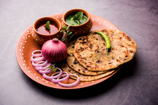 Onion Parotha / Pyaj parantha / kanda paratha served with tomato ketchup and green chutney. selective focus