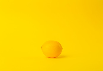 Summer and vitamins background. Lemon on a yellow background, minimal food concept