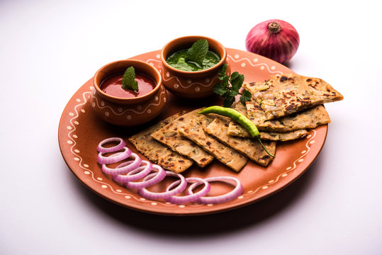Onion Parotha / Pyaj parantha / kanda paratha served with tomato ketchup and green chutney. selective focus