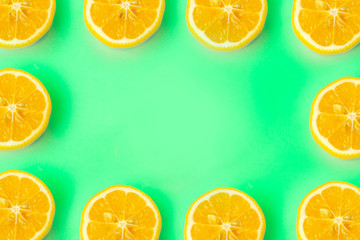 Summer and vitamins background frame. Lemon on a green background, minimal food concept