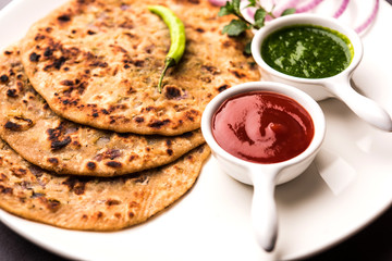 Onion Parotha / Pyaj parantha / kanda paratha served with tomato ketchup and green chutney. selective focus