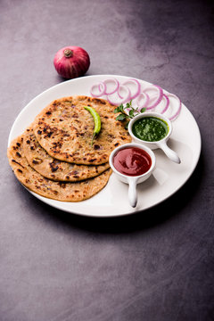 Onion Parotha / Pyaj parantha / kanda paratha served with tomato ketchup and green chutney. selective focus