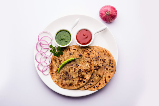 Onion Parotha / Pyaj parantha / kanda paratha served with tomato ketchup and green chutney. selective focus