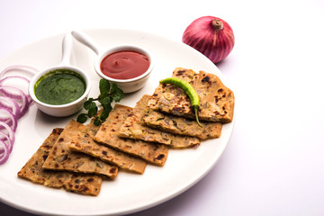 Onion Parotha / Pyaj parantha / kanda paratha served with tomato ketchup and green chutney. selective focus