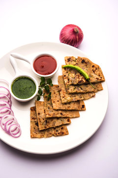 Onion Parotha / Pyaj parantha / kanda paratha served with tomato ketchup and green chutney. selective focus