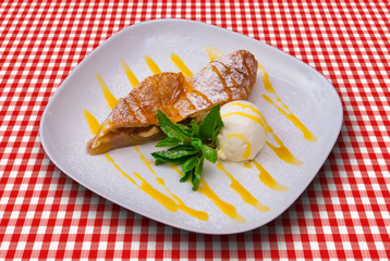 Apple strudel with cream and vanilla sauce