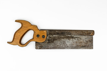 Traditional vintage wooden handled short backsaw with a rusty metal blade shot from above in a white studio.