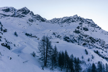 The mountains of the Aosta Valley during the dawn of a winter day near the Matterhorn and the village of Valtournenche, Italy - December 2019.