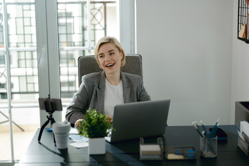 Smiling pretty woman sitting in her office