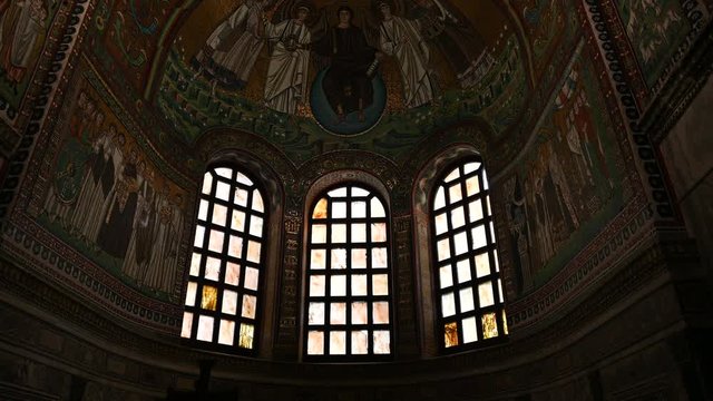 Ravenna, Italy, December 2019. Inside the basilica of San Vitale, footage with tilt movement on the apse decorated with magnificent mosaics. From an initially gloomy image we move on to a clear one