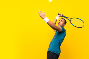 Afro American tennis player man over isolated yellow background