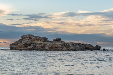 Sunset at the beach of Byblos with a view of a rocky island
