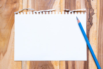 Empty paper sheet on brown wooden table surface for background. Copy space for add text or art work designs.