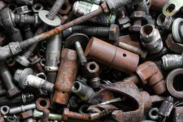 A huge collection of rusty bolts, screws, and nuts on wood.