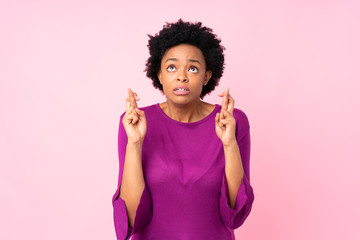 African american woman over isolated pink background with fingers crossing and wishing the best