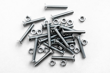 Top view of stainless steel bolts or iron nails on brigth white background with silver color. Metal screws for use in sheet metal.