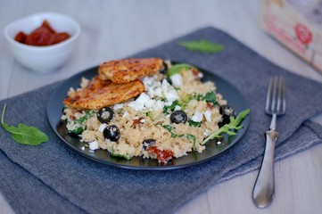 Low carb food chicken fillets white cauliflower rice with dryed tomato, black olive, arugula and cheese