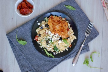 Low carb food chicken fillets white cauliflower rice with dryed tomato, black olive, arugula and cheese
