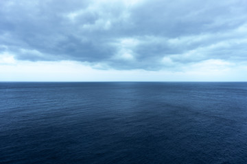 Dark Blue Calm Sea beneath Scenic Clouds