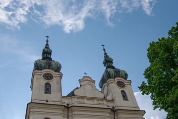 Baroque church with blue sky background and tree on the side