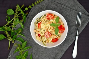 Creamy zucchini spaghetti in sauce with chickpeas,tomato and cheese