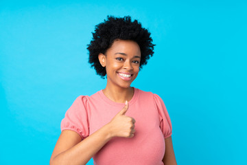 African american woman over isolated blue background giving a thumbs up gesture