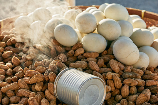 Close-up of steamed peanuts and white boiled eggs for sale on a native bamboo tray with a measuring cup, seen in the Philippines at late afternoon