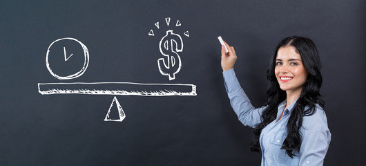 Time and money on the scale with young woman writing on a blackboard