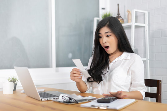 The Panic Asian Woman Checking Expensive Electricity And House Hold Bills, Reads Documents Attentively, Prepares Financial Report, Calculates On Laptop Computer. Finance Interior,domestic Housework