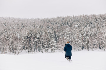 Photographer in winter frost covered forest