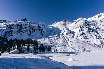 Snowy mountains during a sunny winter day in the alps, near the village of Sankt Moritz and Silvaplana, Switzerland - January 2020