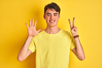 Teenager boy wearing yellow t-shirt over isolated background showing and pointing up with fingers number seven while smiling confident and happy.