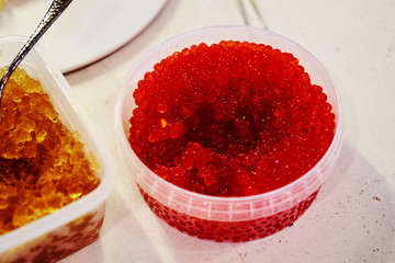 Red caviar in a plastic container. Fresh red salmon caviar