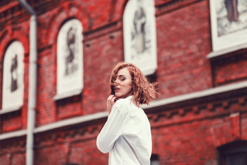 Fototapeta premium Lifestyle portrait woman in white shirt posing in city