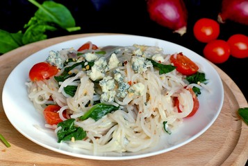 Vegetable salad with rice noodles, spinach, cherry tomato, onion and cheese